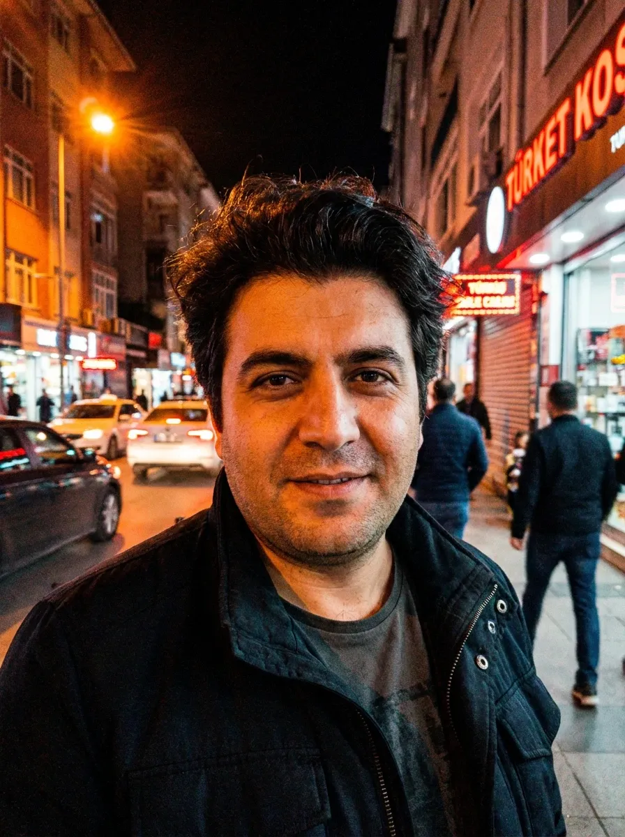 Night street photo of a man in a dark jacket on a city sidewalk